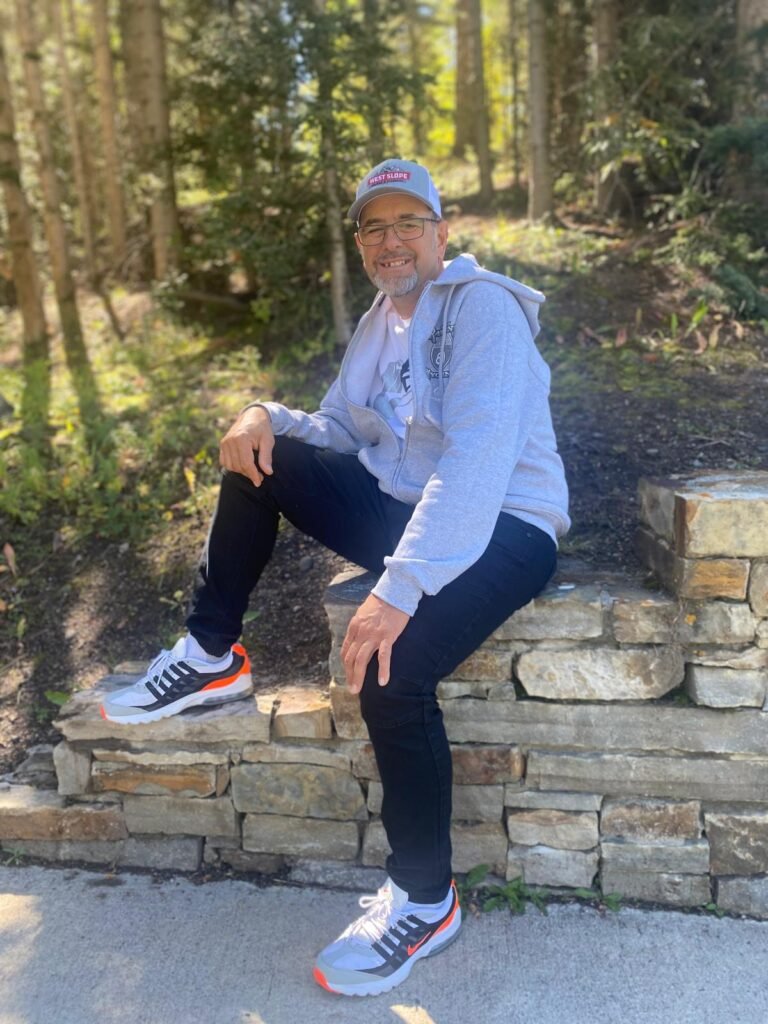 Person sitting on stone wall outdoors.