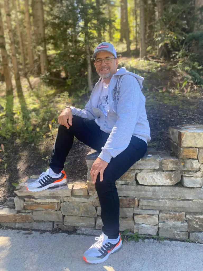 Person sitting on stone wall outdoors.